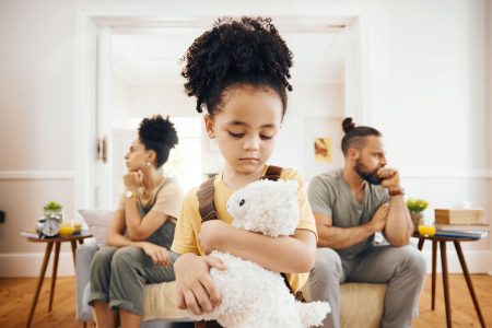 divorce-fight-and-sad-boy-child-with-teddy-bear little girl holding stuffed animal in front of fighting parents