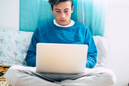 Adobe Express - file (23) Teen sitting on his bed staring at a laptop