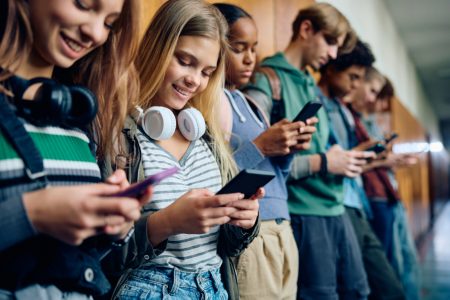 Teen boys and girls checking their phones
