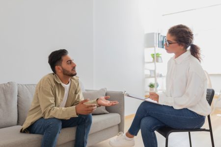 Man on couch speaking with a mental health counselor